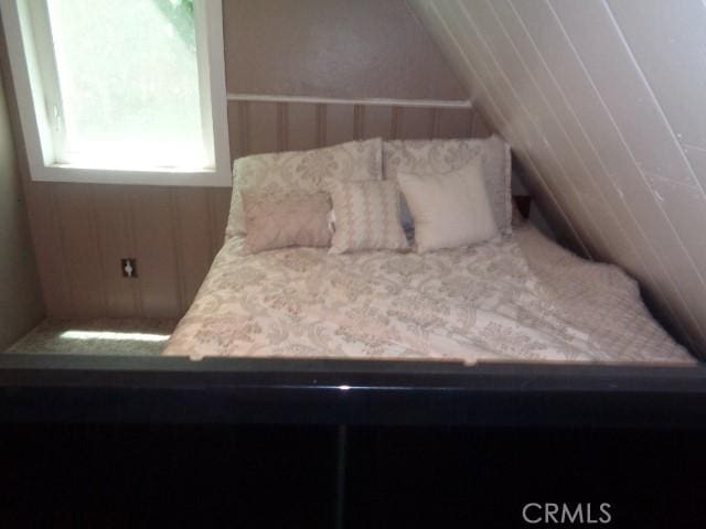 unfurnished bedroom featuring lofted ceiling