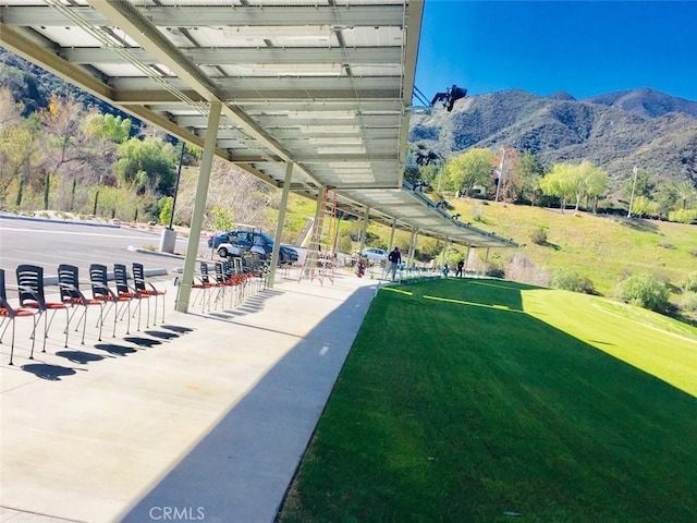 view of property's community featuring a lawn and a mountain view