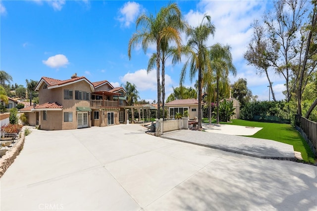 view of front of property featuring a balcony and a front yard