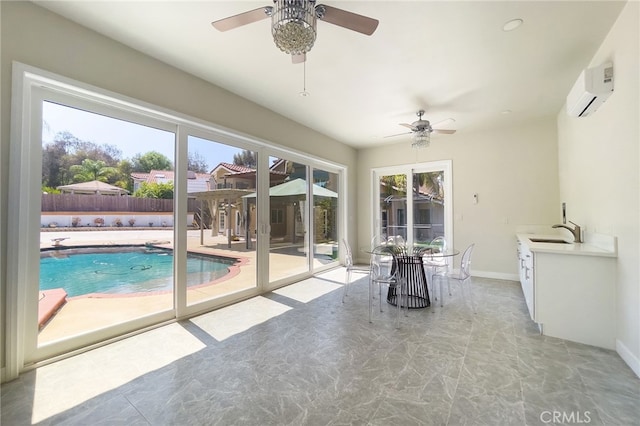 sunroom featuring sink, ceiling fan, and a wall unit AC