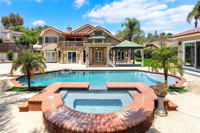 view of swimming pool featuring an in ground hot tub and a patio area