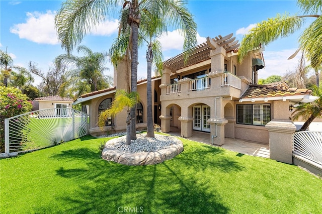 rear view of house featuring a balcony, a patio, and a yard