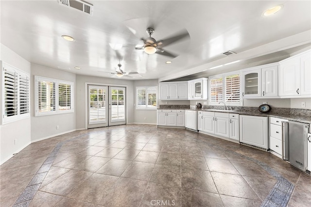 kitchen with white cabinets, white dishwasher, ceiling fan, french doors, and sink