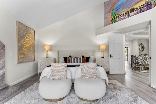 bedroom with hardwood / wood-style floors and high vaulted ceiling