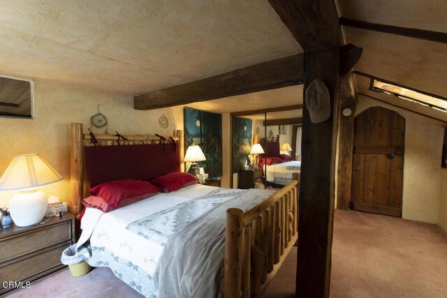 carpeted bedroom with beam ceiling