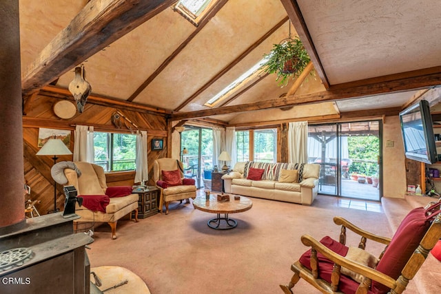 carpeted living room featuring wooden walls and lofted ceiling with skylight