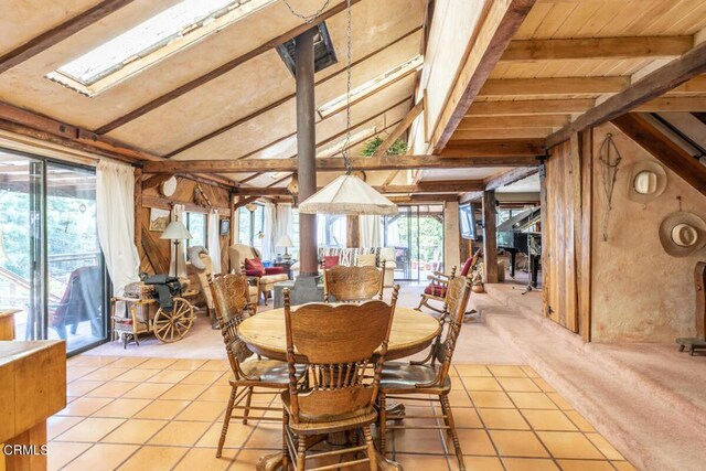 dining area with wooden ceiling, vaulted ceiling with skylight, and light tile patterned flooring