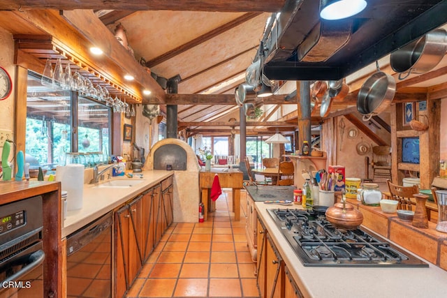 kitchen with stainless steel gas stovetop, light tile patterned flooring, lofted ceiling with beams, and plenty of natural light