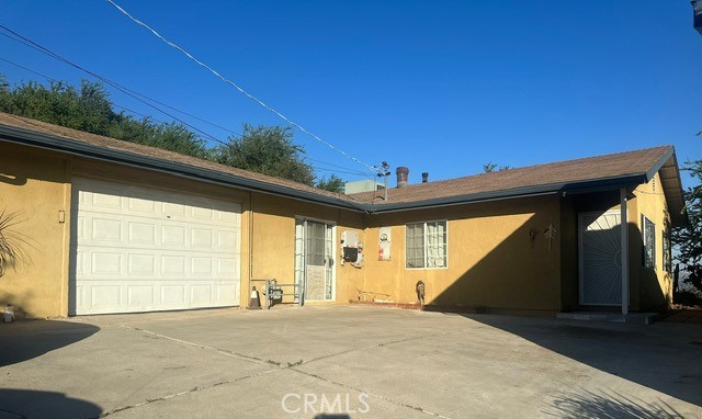 ranch-style home with driveway, an attached garage, and stucco siding