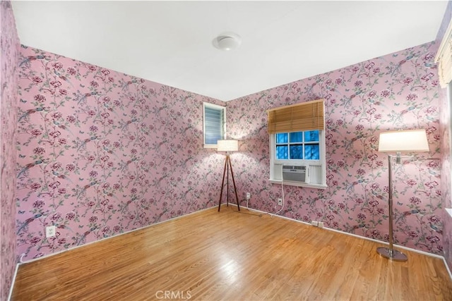 empty room with cooling unit and wood-type flooring