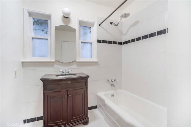 bathroom with vanity, tile walls, and tiled shower / bath