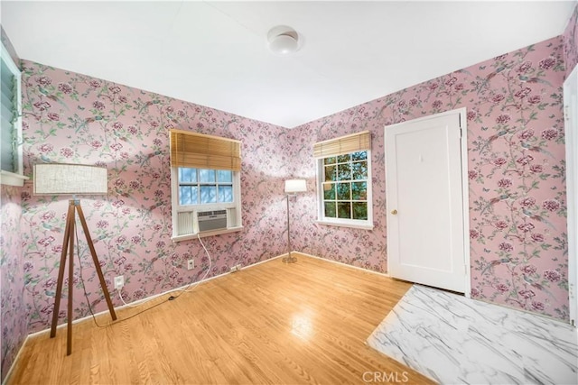 empty room with wood-type flooring, plenty of natural light, and cooling unit