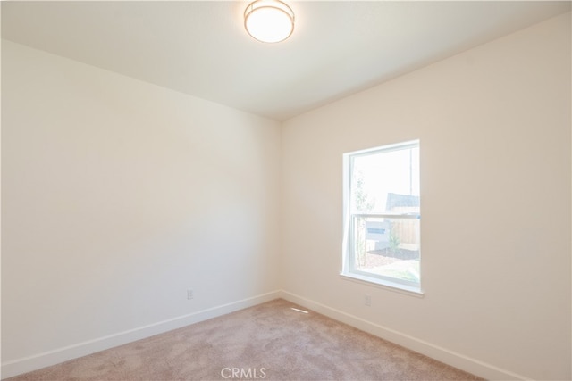 unfurnished room featuring light carpet