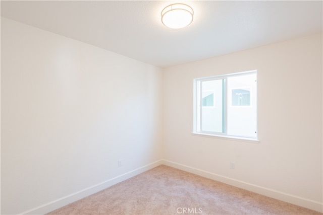 spare room featuring light colored carpet