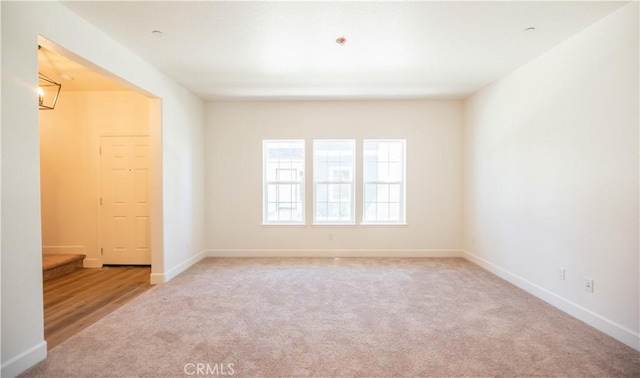 carpeted spare room with baseboards