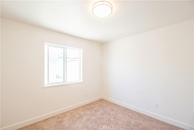empty room with light colored carpet and baseboards