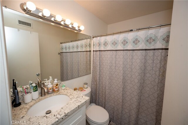 bathroom featuring vanity, toilet, and a shower with shower curtain