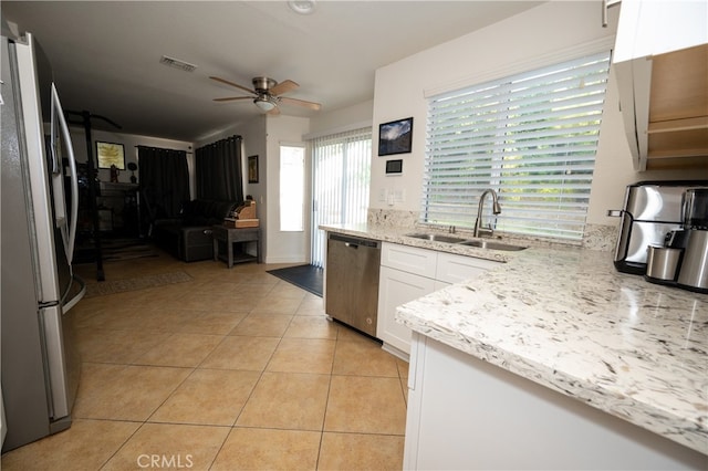 kitchen with light tile patterned flooring, sink, white cabinets, stainless steel appliances, and ceiling fan