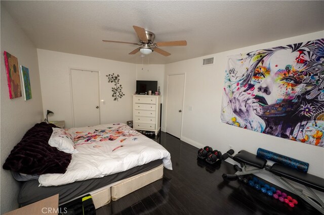 bedroom with ceiling fan, hardwood / wood-style flooring, and a textured ceiling