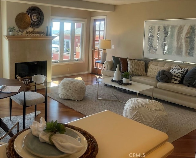 living room featuring wood-type flooring and a tile fireplace