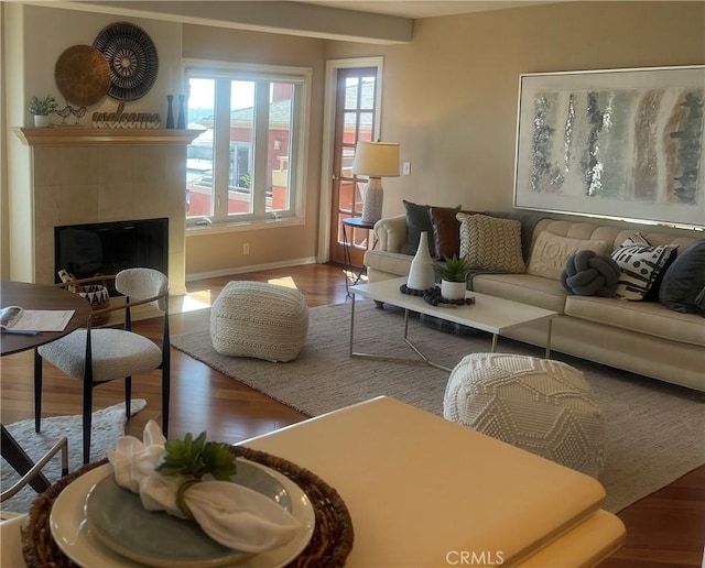 living room with wood-type flooring and a tile fireplace