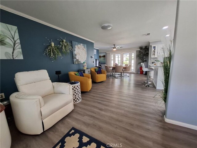 living room with ceiling fan, wood-type flooring, and crown molding