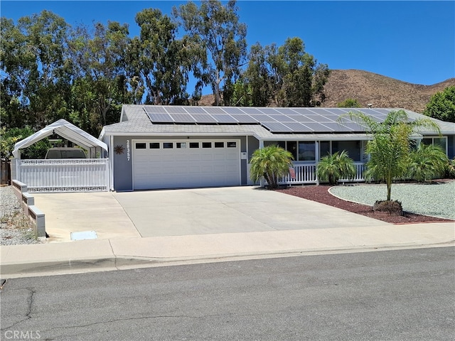 ranch-style home with a mountain view, covered porch, and a garage