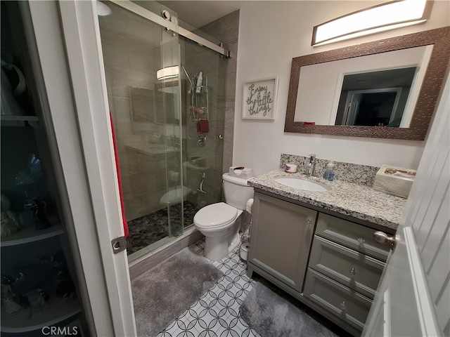 bathroom with tile patterned flooring, vanity, toilet, and a shower with door