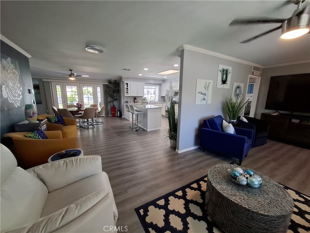 living room featuring crown molding, ceiling fan, and dark wood-type flooring