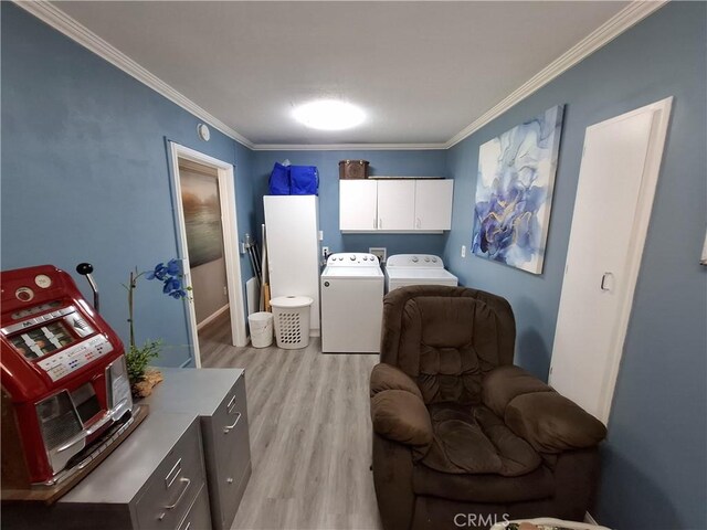 washroom with cabinets, light hardwood / wood-style floors, washer and clothes dryer, and crown molding