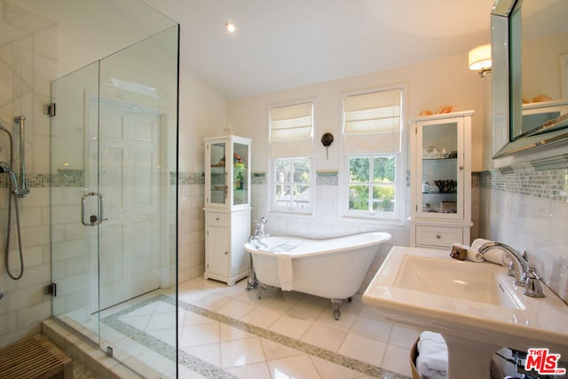 bathroom featuring shower with separate bathtub, sink, tile patterned floors, and tile walls