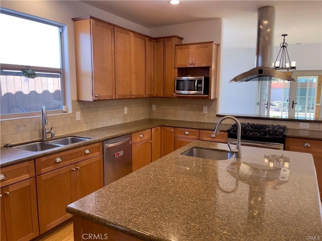 kitchen with island range hood, sink, appliances with stainless steel finishes, and tasteful backsplash