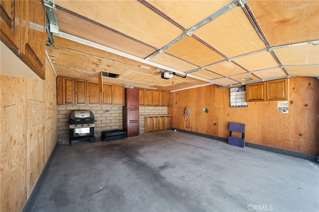 garage with a garage door opener and wood walls