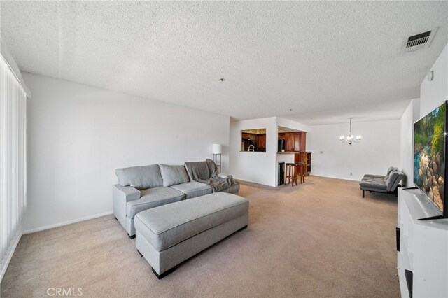 carpeted living room with an inviting chandelier and a textured ceiling