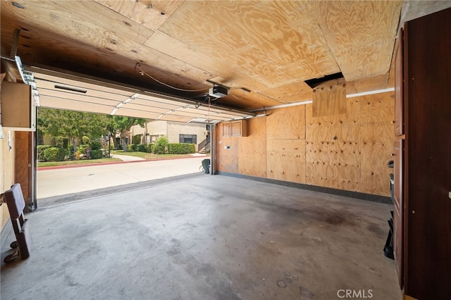 garage with wooden ceiling, a garage door opener, and wooden walls