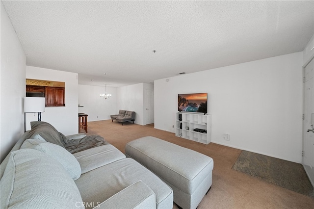 carpeted living room with a notable chandelier and a textured ceiling