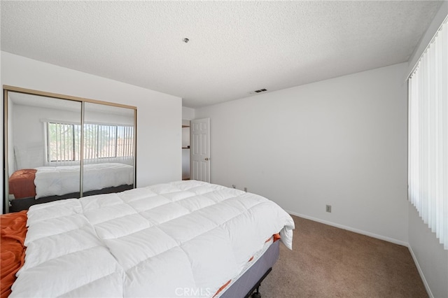 bedroom featuring a textured ceiling, a closet, and carpet flooring