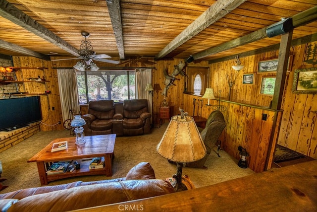 carpeted living room with beamed ceiling, ceiling fan, wood ceiling, and wooden walls