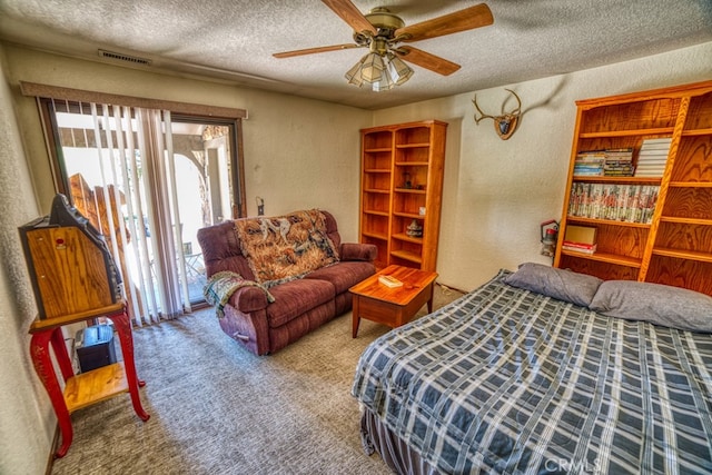 carpeted bedroom featuring ceiling fan and a textured ceiling