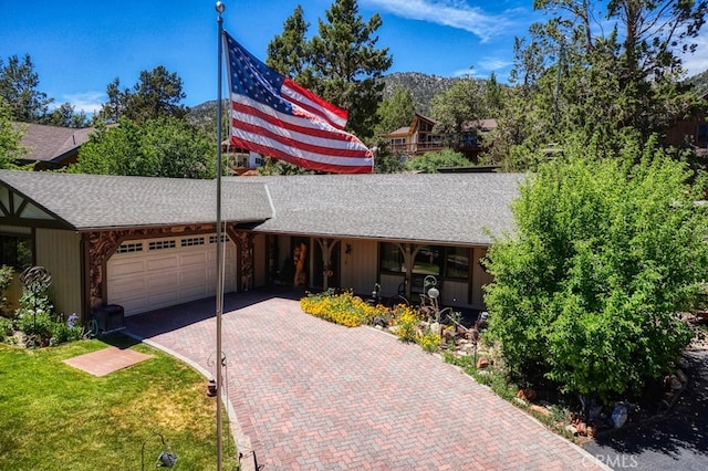 view of front of home with a mountain view, a front lawn, and a garage