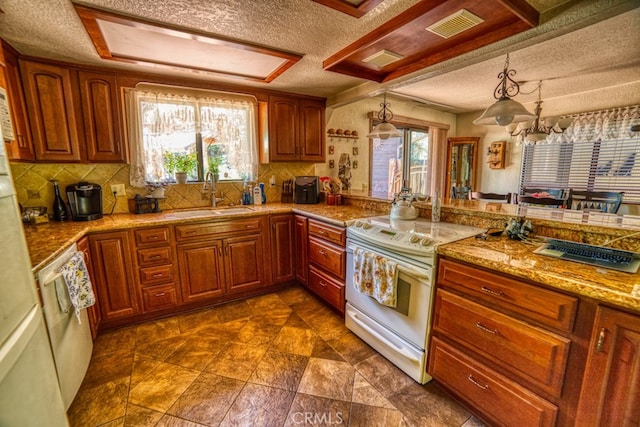 kitchen with kitchen peninsula, white appliances, sink, pendant lighting, and an inviting chandelier