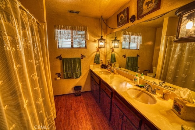 bathroom featuring hardwood / wood-style floors, vanity, a healthy amount of sunlight, and toilet