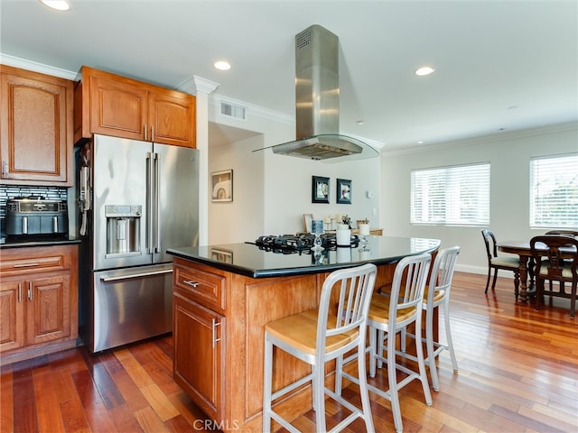 kitchen featuring island range hood, a kitchen island, dark hardwood / wood-style flooring, high quality fridge, and ornamental molding