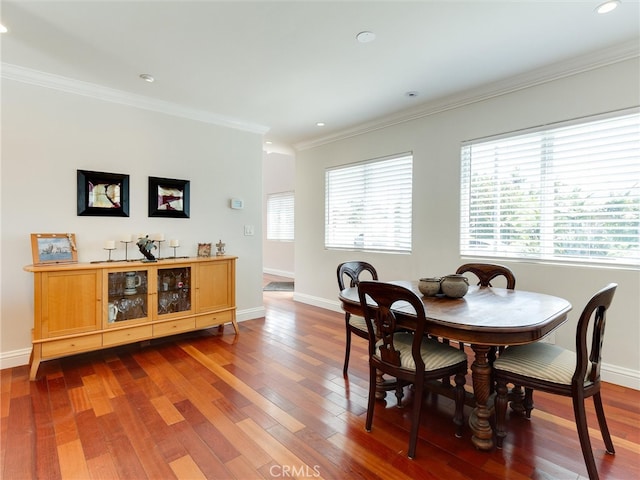 dining area with wood-type flooring and ornamental molding