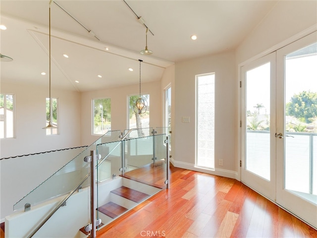 interior space featuring light wood-type flooring, vaulted ceiling, and french doors