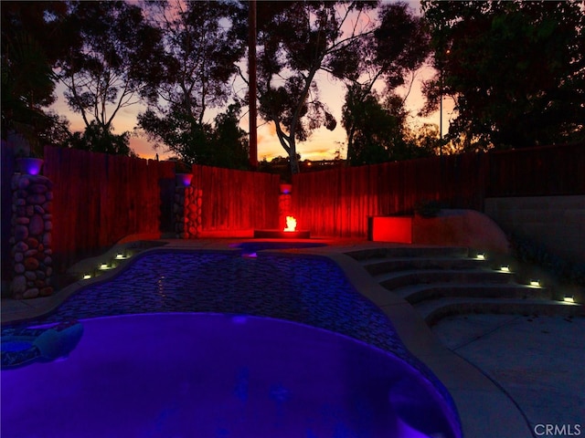 view of pool at dusk