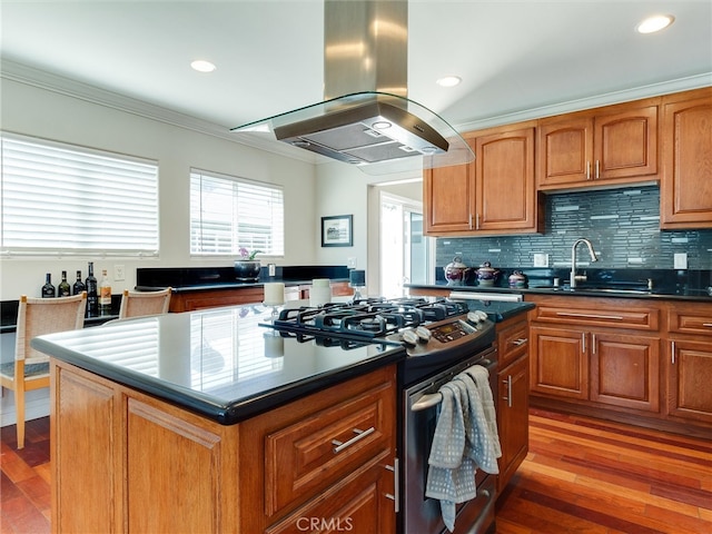 kitchen with a kitchen island, island exhaust hood, gas range, dark hardwood / wood-style floors, and sink