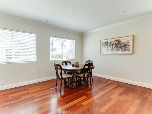 dining area featuring crown molding and hardwood / wood-style flooring