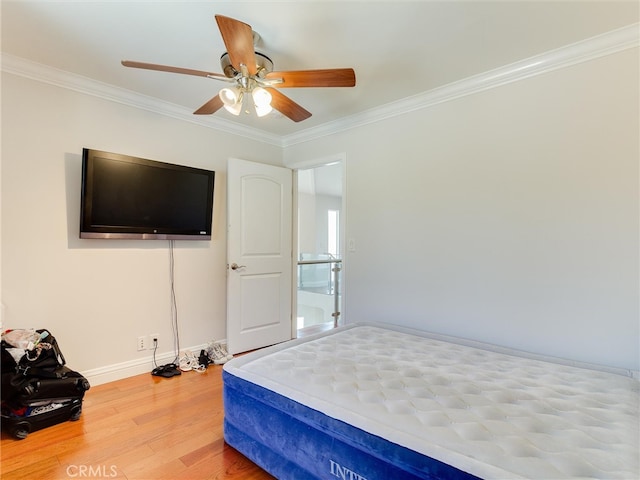 bedroom with crown molding, ceiling fan, and hardwood / wood-style flooring