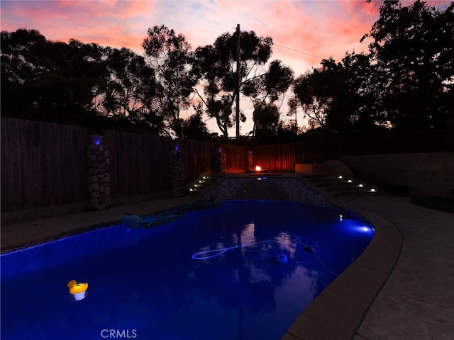 view of pool at dusk